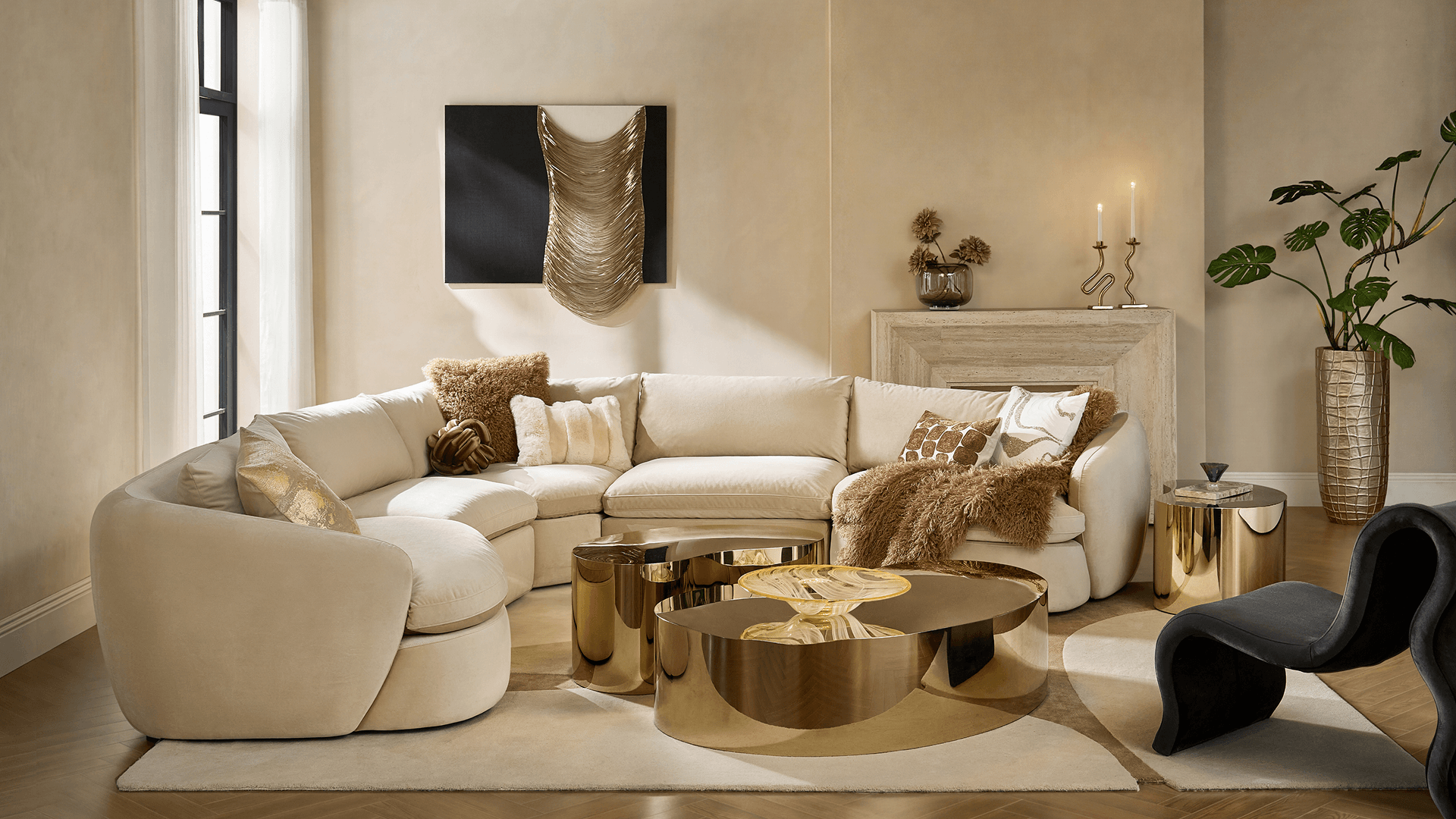 Modern beige curved sectional sofa paired with polished brass coffee tables in a luxury living room setting