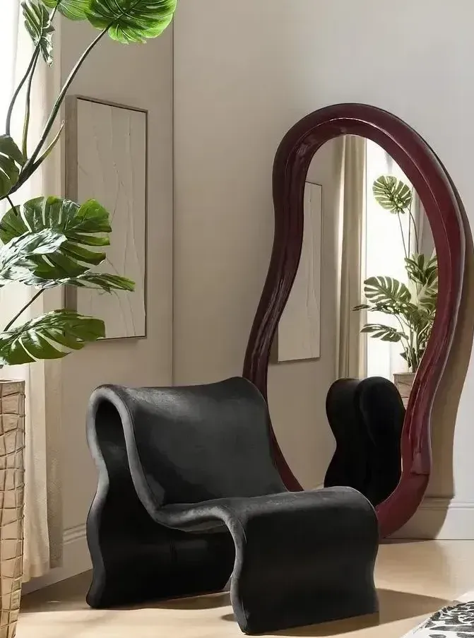 Oversized floor mirror in a luxury living room reflecting natural light beside textured seating
