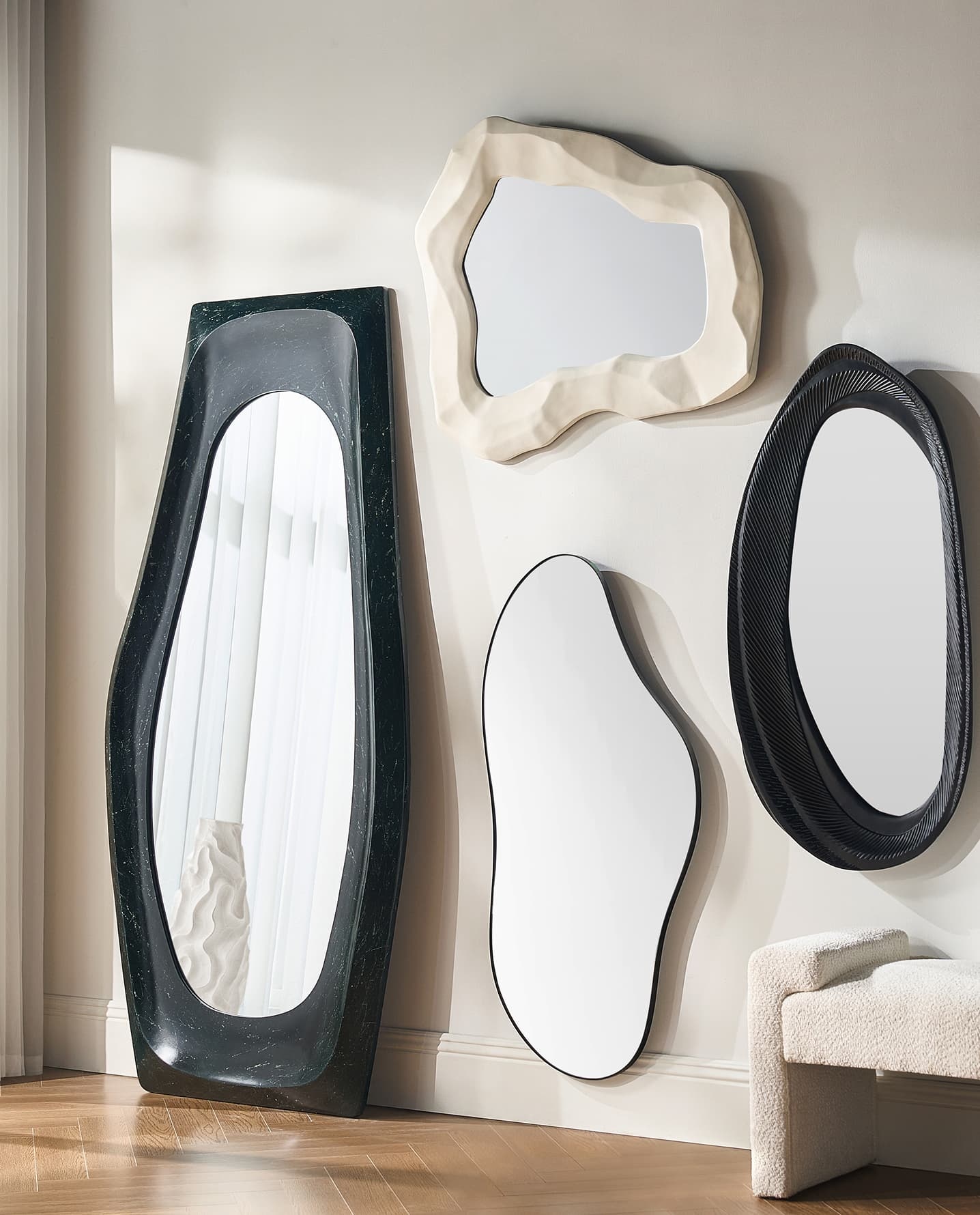 Asymmetrical decorative wall mirrors in sculptural black, white, and cream frames for modern home decor and interior design.