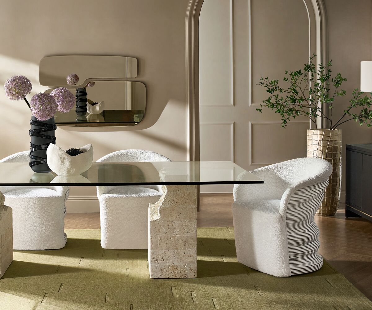 Cairo Mactan stone dining table with a clear glass top and a textured neutral stone base.