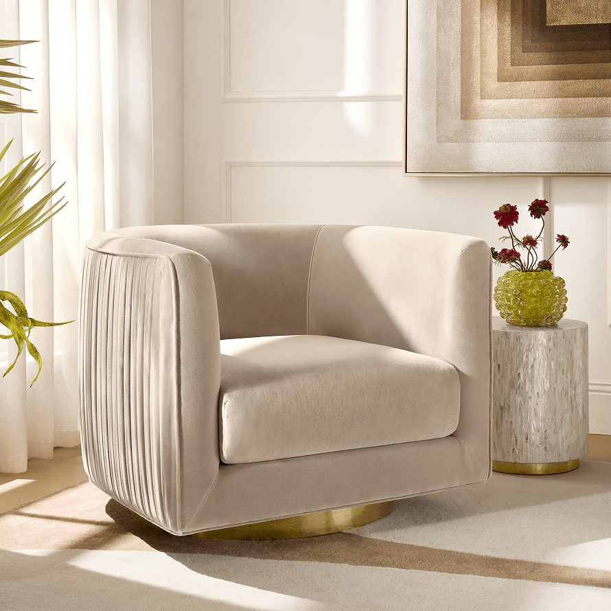 Contemporary living space featuring a cream velvet swivel armchair with a brushed brass base alongside a travertine side table and neutral framed art.