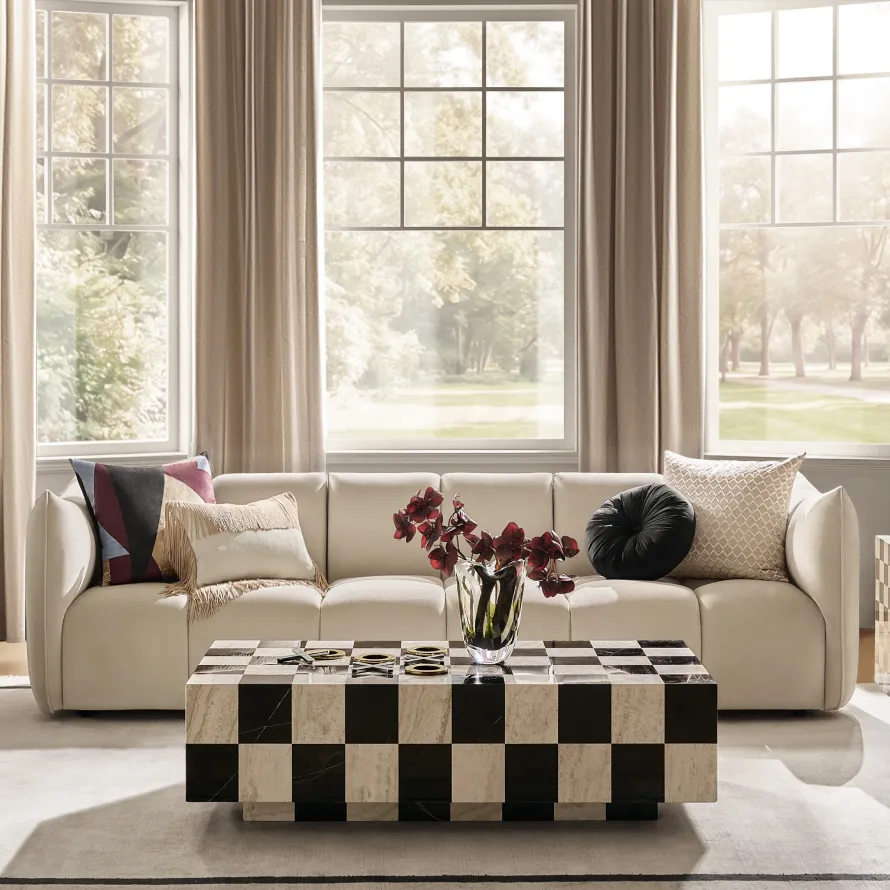 A bright modern living room with a black and beige marble checkerboard coffee table, a cream upholstered sofa, and large French grid windows.