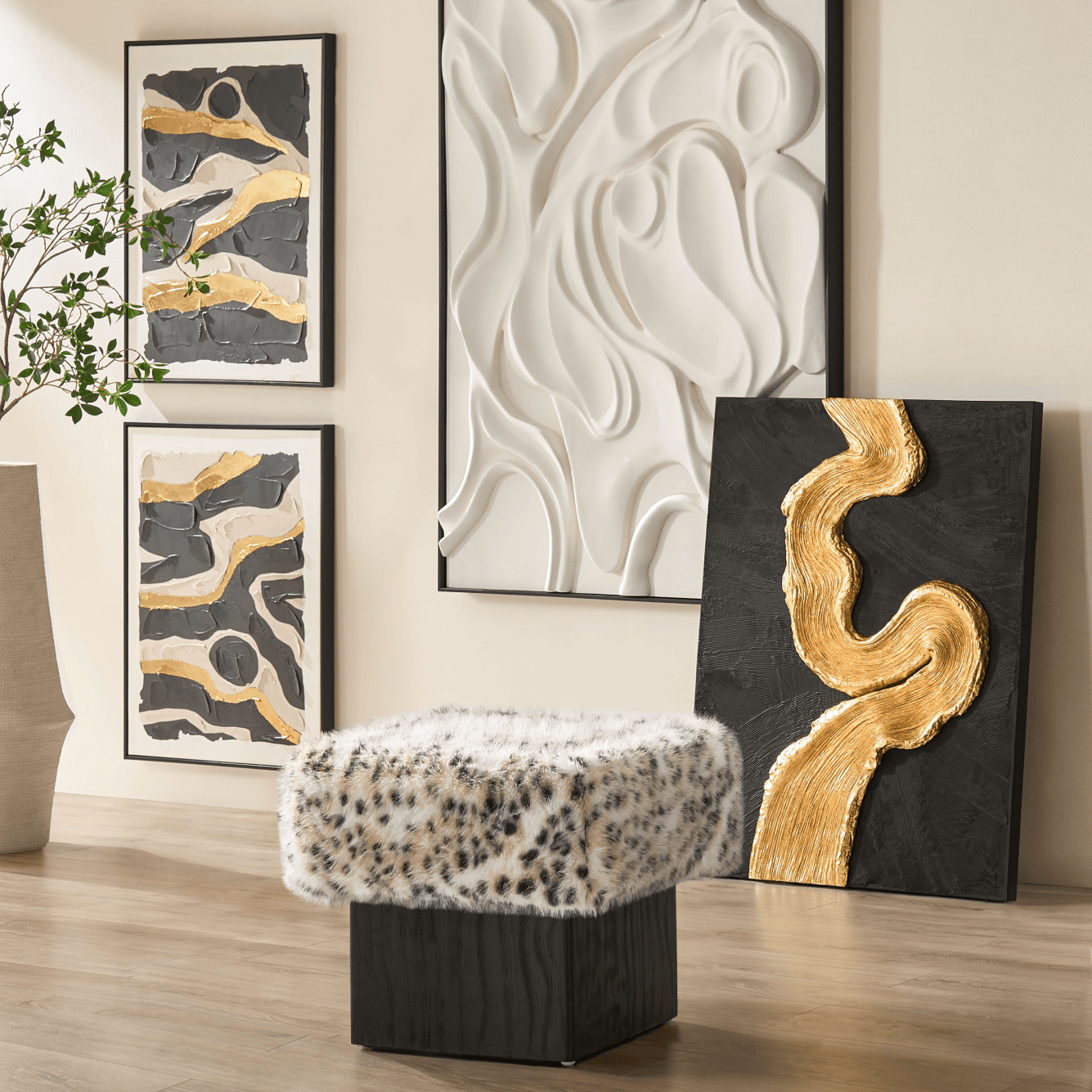 Gallery wall showcasing 3D white relief wall art, black and gold abstract canvas paintings, and a leopard print ottoman.