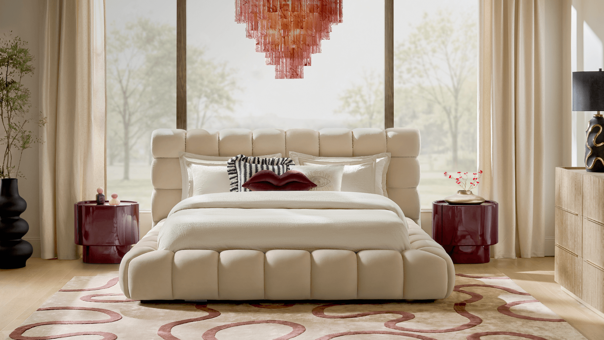 Modern luxury bedroom featuring a plush channeled cream upholstered bed, deep burgundy lacquer nightstands, a pink crystal tiered chandelier, and patterned area rug.
