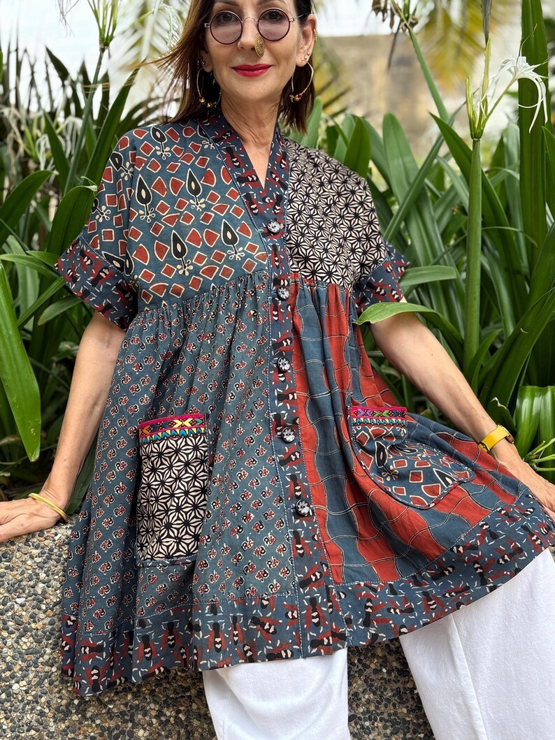 Loose fitting indigo blue and red cotton tunic is from artisan made Ajrakh fabric. Colorful Kutch hand embroidery highlights the pockets