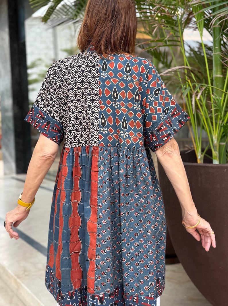 Loose fitting indigo blue and red cotton tunic is from artisan made Ajrakh fabric. Colorful Kutch hand embroidery highlights the pockets