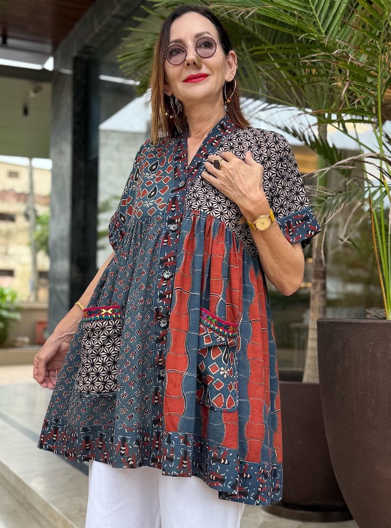 Loose fitting indigo blue and red cotton tunic is from artisan made Ajrakh fabric. Colorful Kutch hand embroidery highlights the pockets