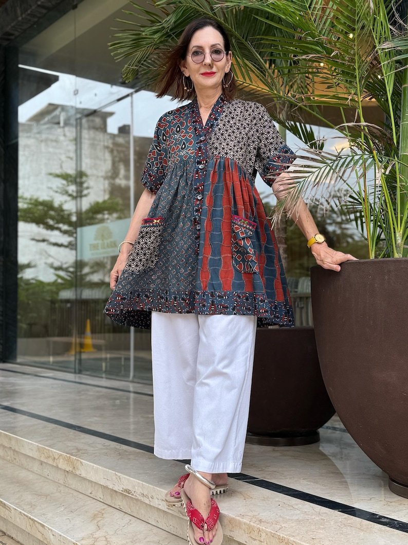 Loose fitting indigo blue and red cotton tunic is from artisan made Ajrakh fabric. Colorful Kutch hand embroidery highlights the pockets