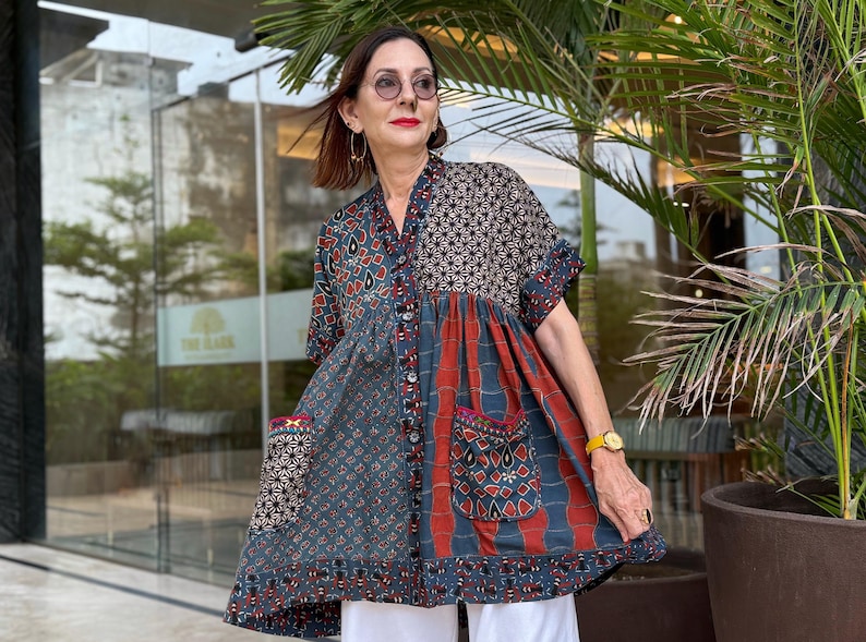 Loose fitting indigo blue and red cotton tunic is from artisan made Ajrakh fabric. Colorful Kutch hand embroidery highlights the pockets