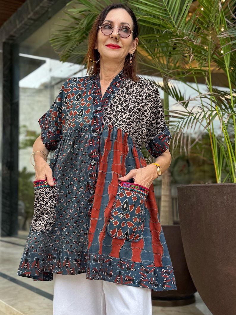 Loose fitting indigo blue and red cotton tunic is from artisan made Ajrakh fabric. Colorful Kutch hand embroidery highlights the pockets