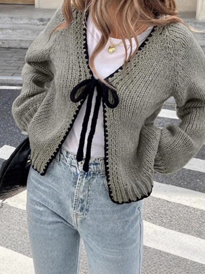 Women's solid color loose-fitting knitted cardigan with tie closure.