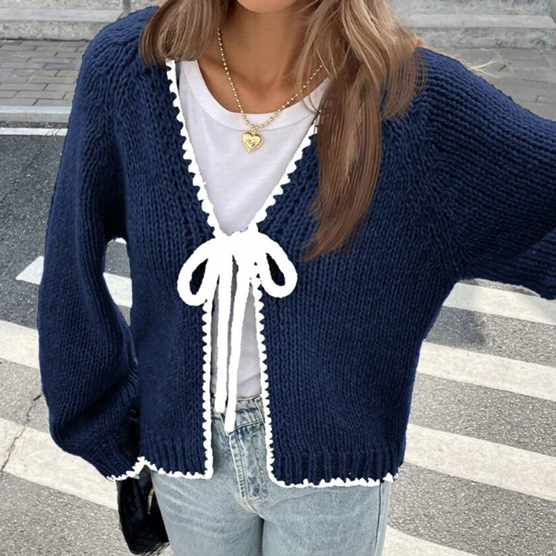 Women's solid color loose-fitting knitted cardigan with tie closure.