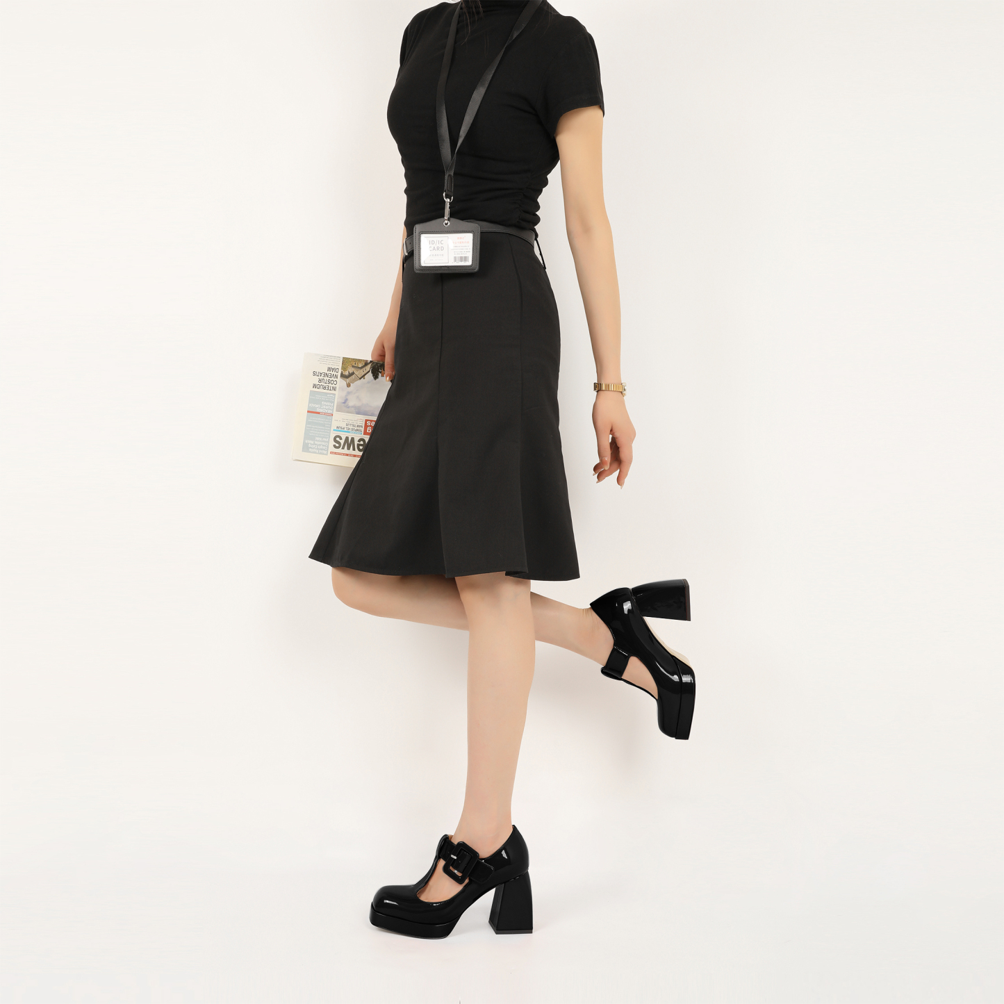 Close-up of model wearing black Mary Jane platform pumps with buckle strap and square toe