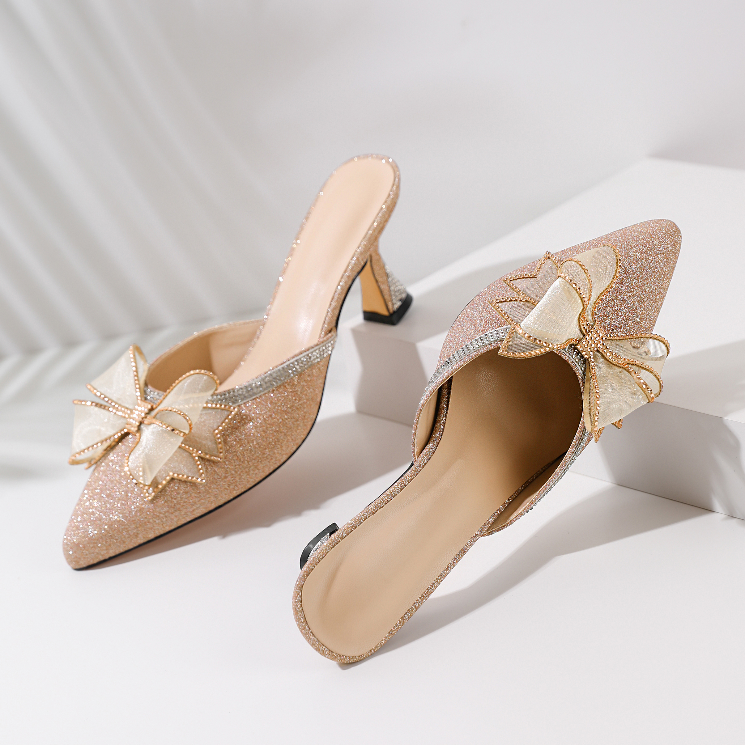 Gold stiletto low heels close-up of rhinestone ankle strap

