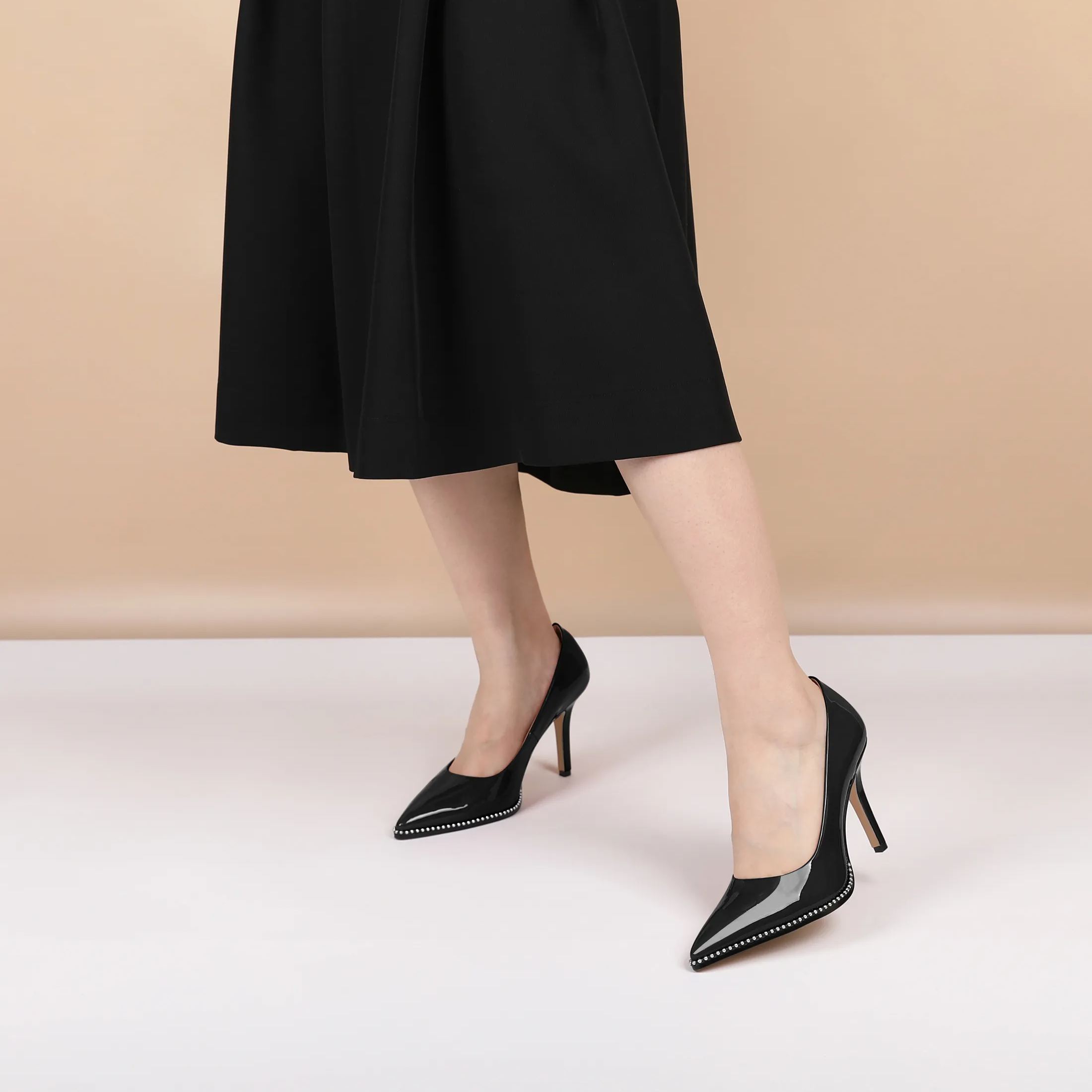 Woman pairing nude pointed toe pumps with office outfit