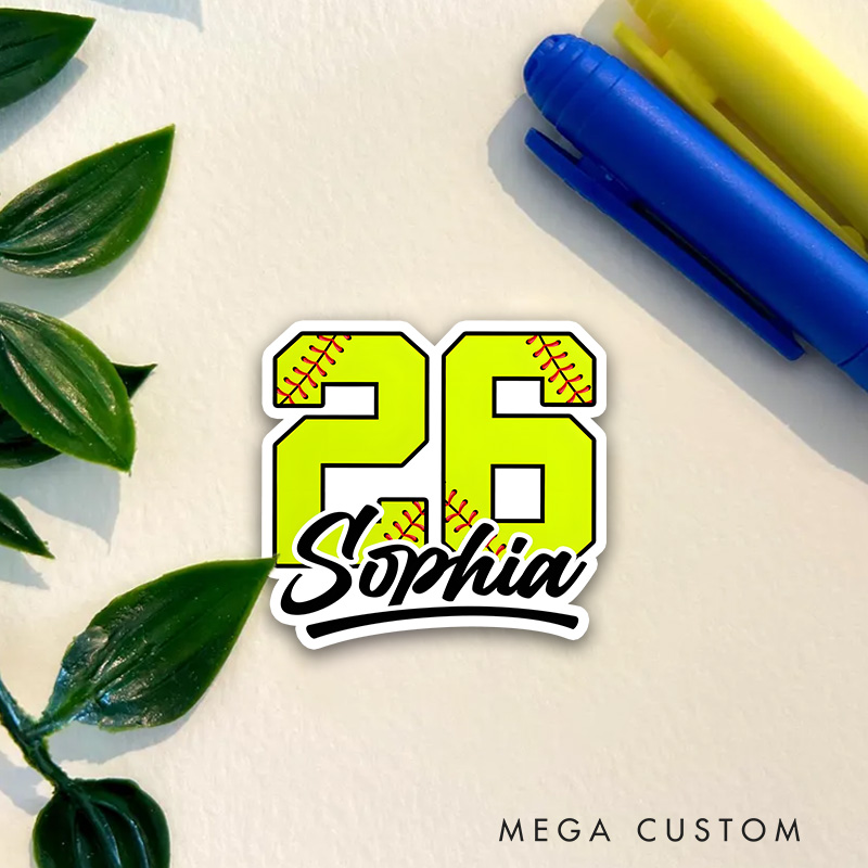 Personalized Softball Decal Featuring a Bold Custom Number in Vibrant Yellow with Realistic Red Softball Stitching Accented by a Custom Name in Elegant Black Script Lettering and a Dynamic Underline