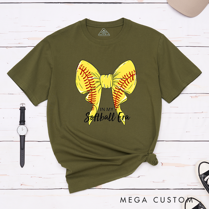 Personalized Softball Era T-Shirt Design Showcasing a Vibrant Yellow Bow Inspired by Softball Stitching Paired with Customizable Text Perfect for Teams Players and Fans to Celebrate Their Love for the Game in Style