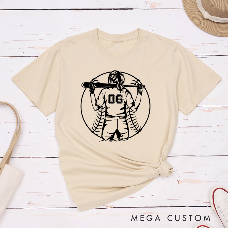 Personalized Softball Player T-Shirt Design Featuring a Back View of a Batter Holding a Bat Customizable Jersey Number and Bold Softball Stitching Graphic in the Background