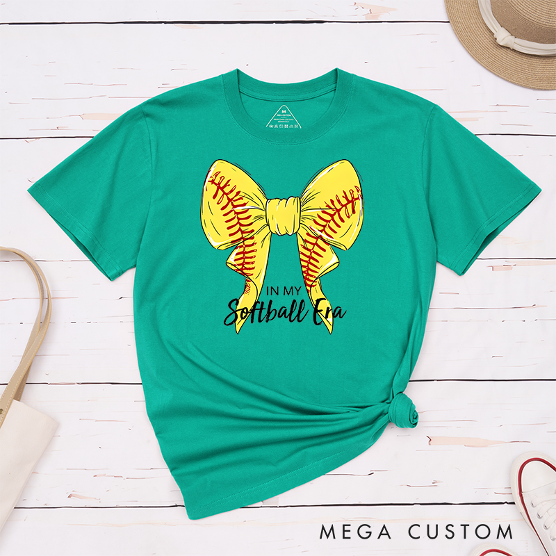 Personalized Softball Era T-Shirt Design Showcasing a Vibrant Yellow Bow Inspired by Softball Stitching Paired with Customizable Text Perfect for Teams Players and Fans to Celebrate Their Love for the Game in Style