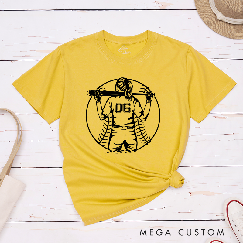 Personalized Softball Player T-Shirt Design Featuring a Back View of a Batter Holding a Bat Customizable Jersey Number and Bold Softball Stitching Graphic in the Background