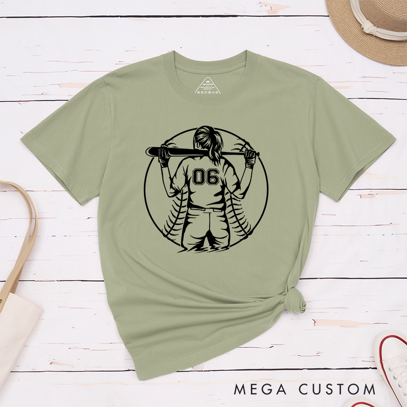 Personalized Softball Player T-Shirt Design Featuring a Back View of a Batter Holding a Bat Customizable Jersey Number and Bold Softball Stitching Graphic in the Background