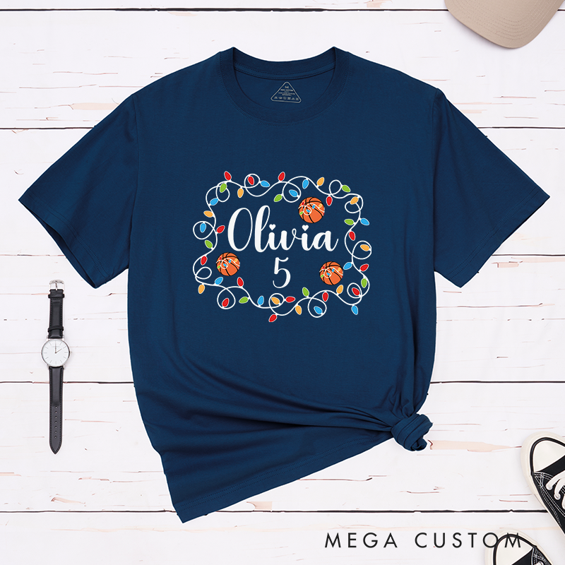 Personalized Christmas T-Shirt with Custom Name, Number, Basketballs, and Festive String Lights Design