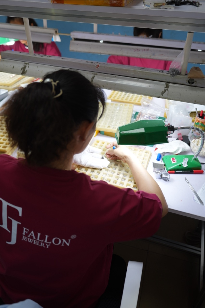 Worker inspecting and adjusting jewelry pieces by hand