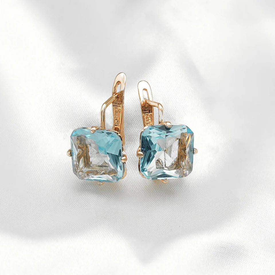 "Gold latch back earrings with cushion-cut light blue gemstones, elegant and reflective."
Earrings (All Categories) from FJ Fallon Jewelry