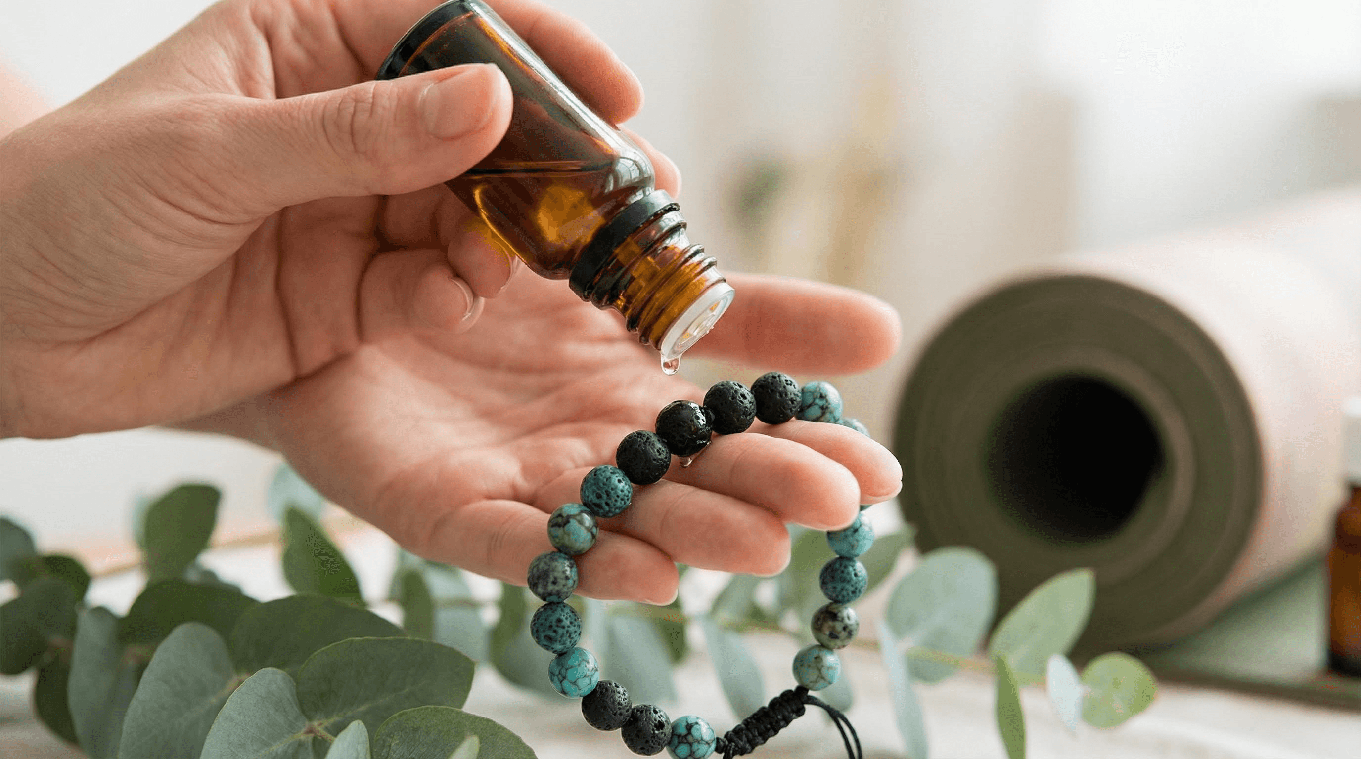 Applying essential oil to a 7 chakra lava stone bracelet for wearable aromatherapy benefits.