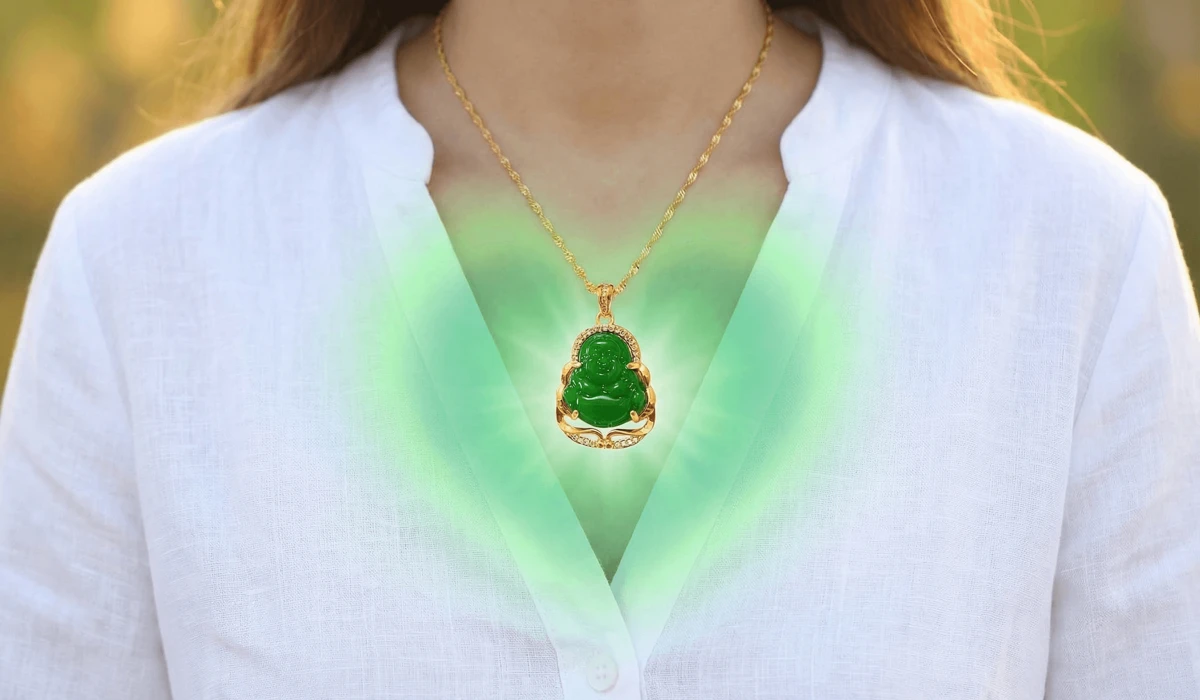 A green jade Buddha pendant glowing with emerald light near the heart chakra, representing emotional balance and spiritual connection.