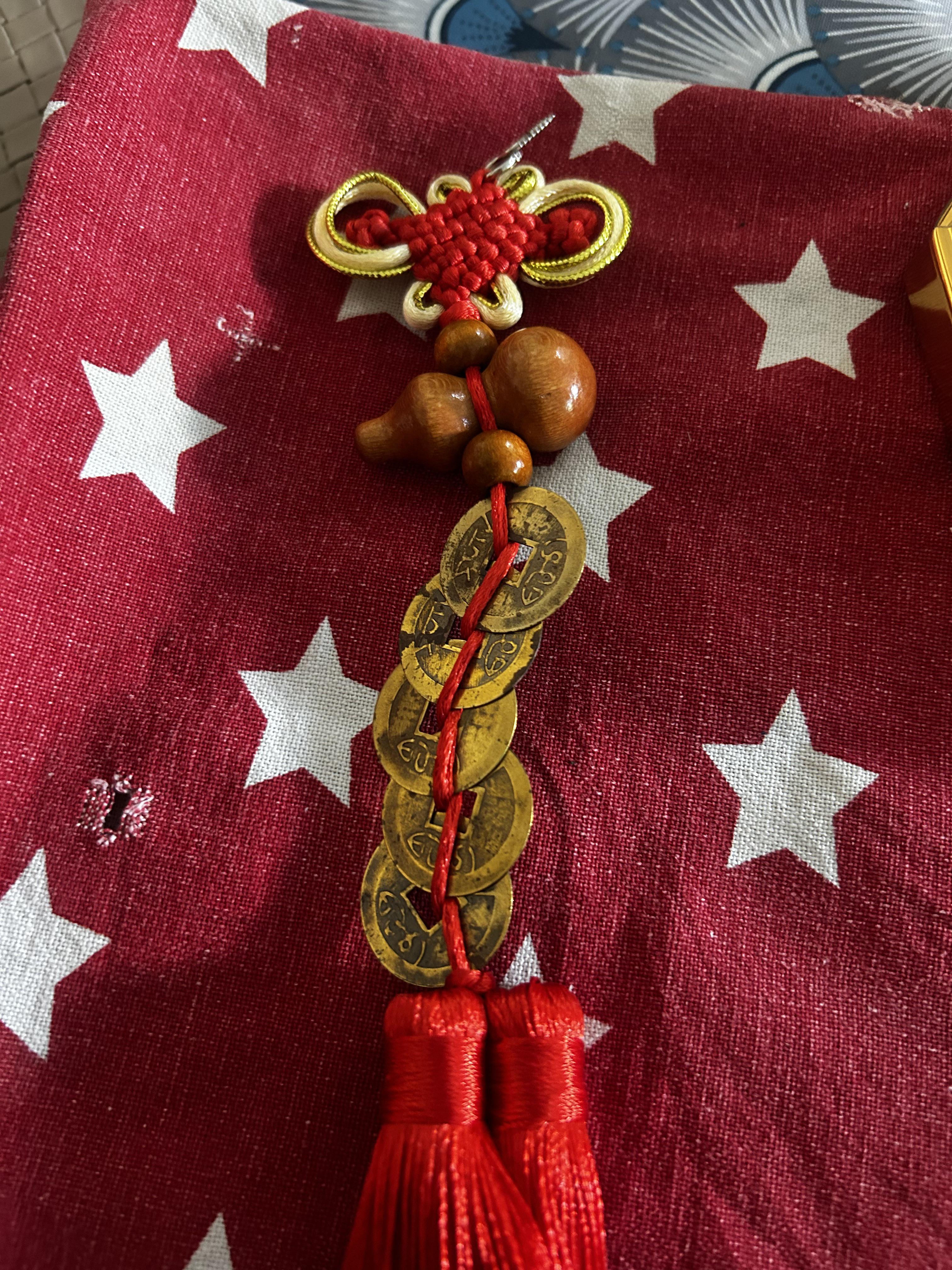 A Feng Shui charm being held, showing intricate details of traditional symbols.
