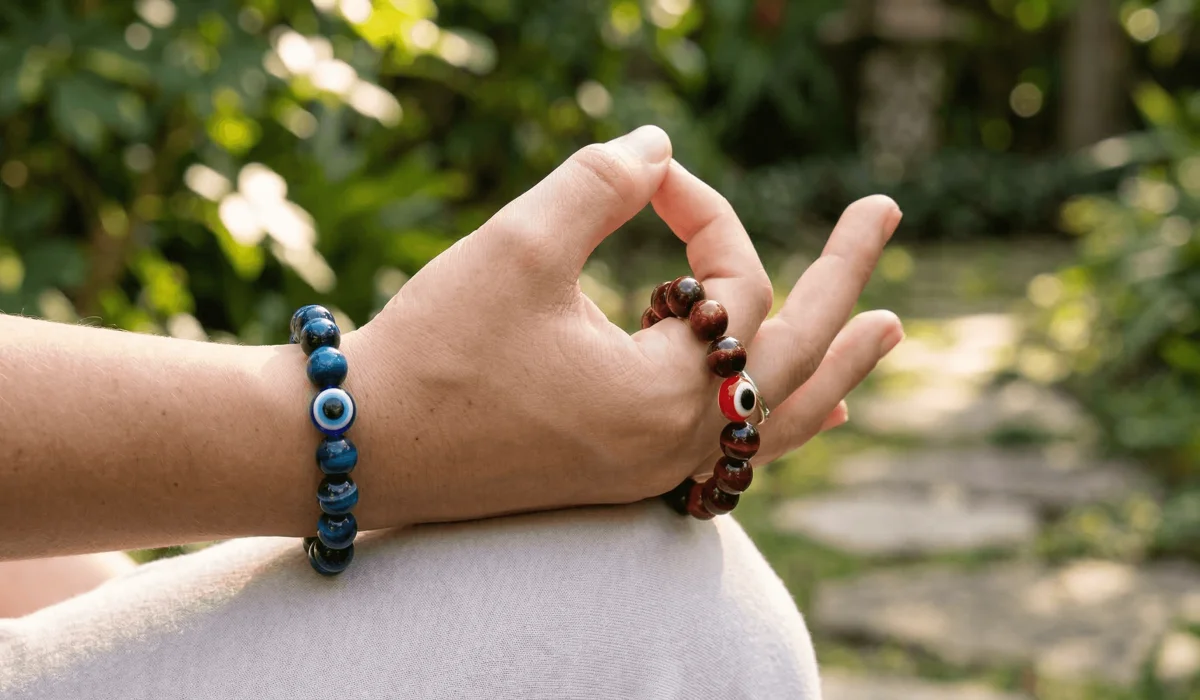 Close-up of Blue and Red Tiger's Eye bracelets worn on left and right hands for spiritual balance and manifestation.