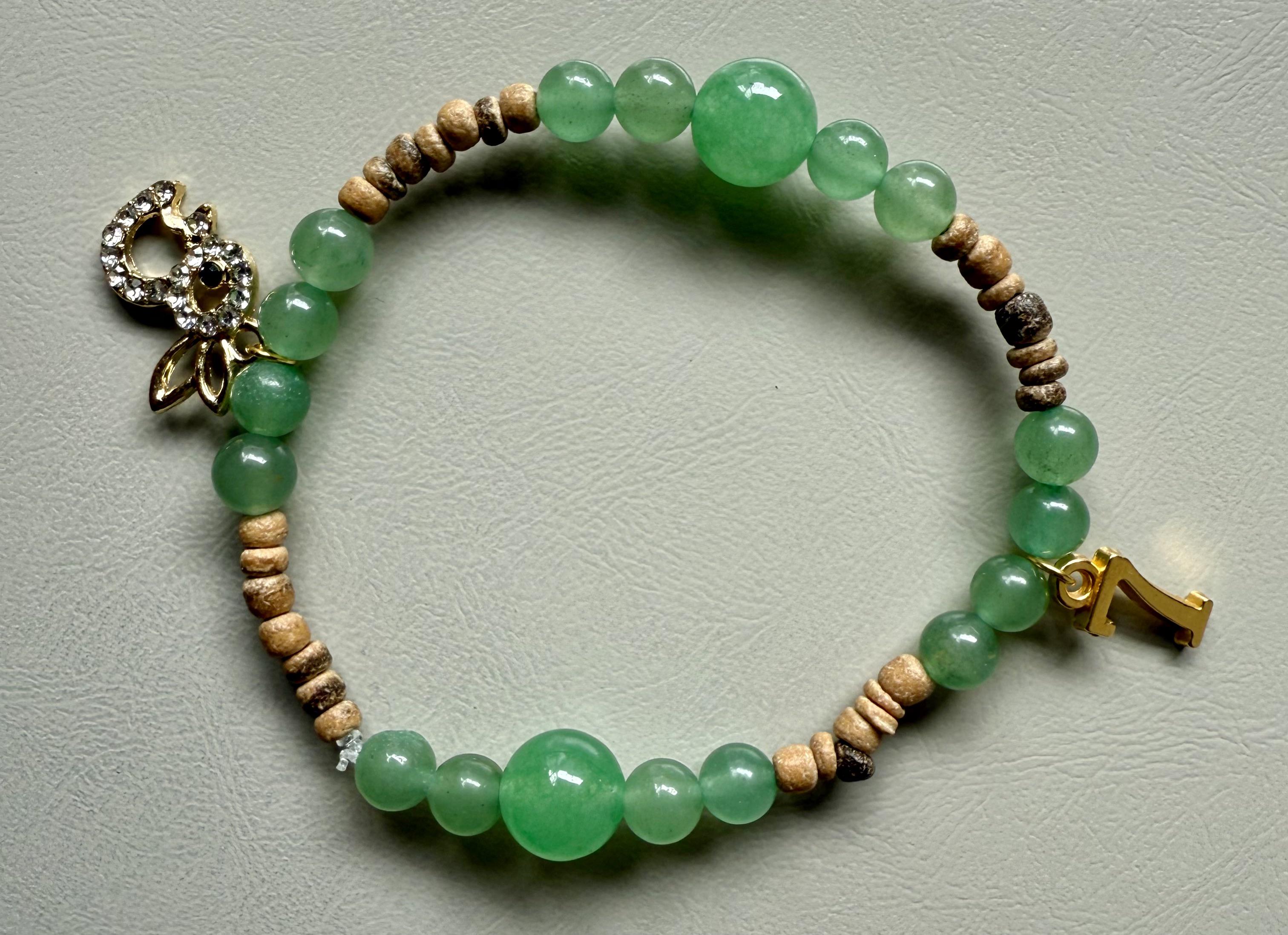 A handmade bracelet featuring Green Aventurine beads and coconut wood.