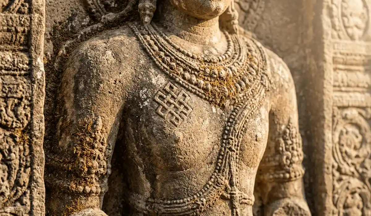 Ancient stone relief of the Srivatsa mark on a deity's heart, illustrating the historical origins of the Endless Knot.