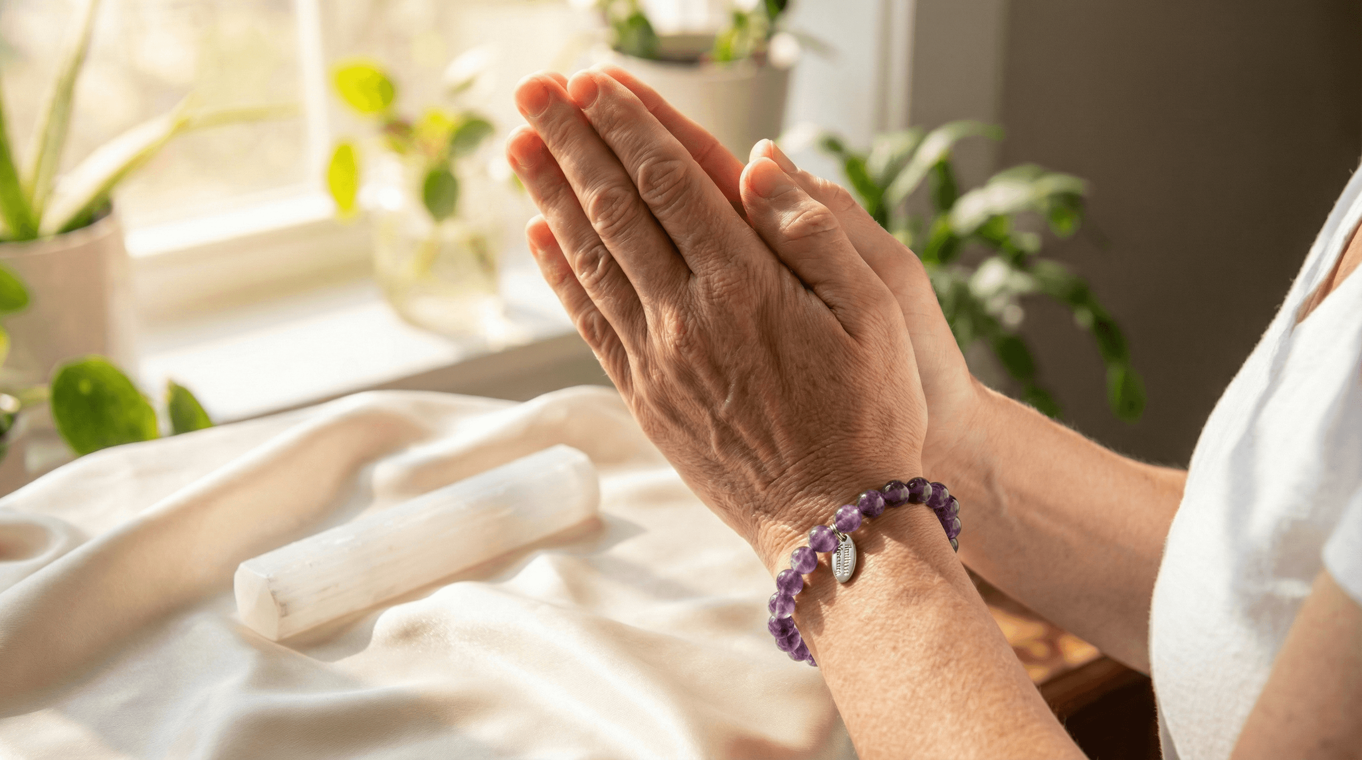 Close-up of a person wearing an Amethyst bracelet for spiritual connection during a mindfulness practice.