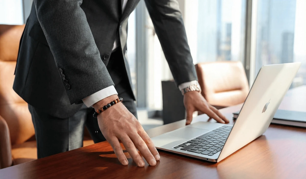 Professional man wearing a triple protection bracelet on his left wrist in a corporate office setting for confidence and protection.