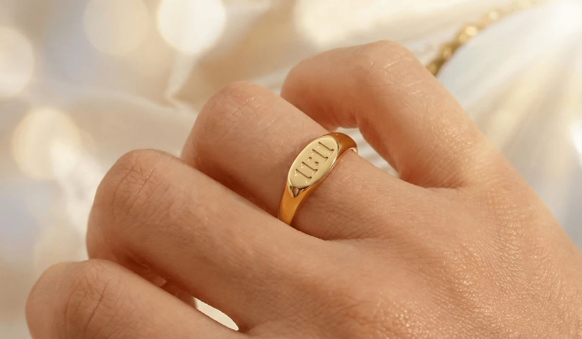 Close-up of a gold 111 angel number ring on a finger, symbolizing new beginnings and manifestation.