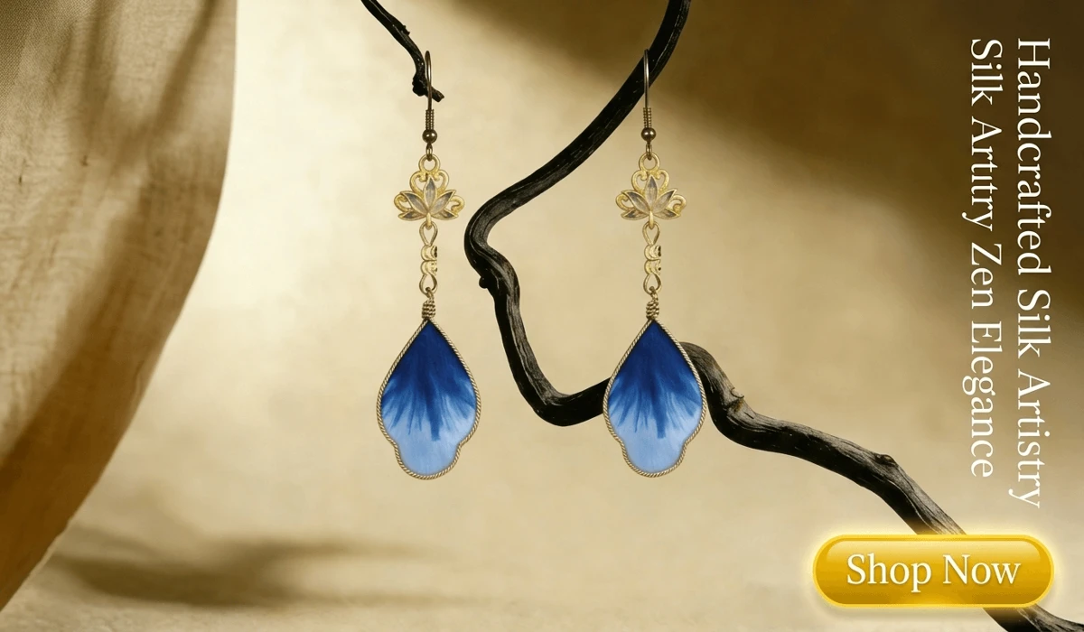 Ethereal Lotus silk flower (RONGHUA) blue gradient and gold earrings displayed on a Zen-style wooden branch for a luxury jewelry blog.