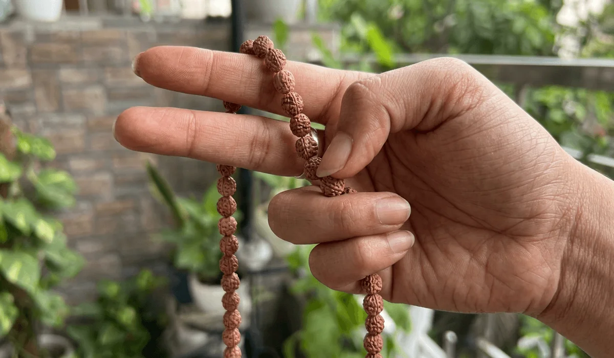 Correct hand placement for Japa meditation using the thumb and middle finger to move Bodhi beads.