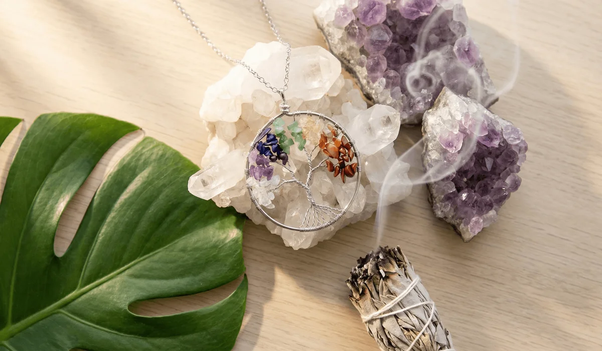 A Tree of Life necklace being cleansed with sage and charged on crystals to refresh its spiritual healing properties and positive energy flow.