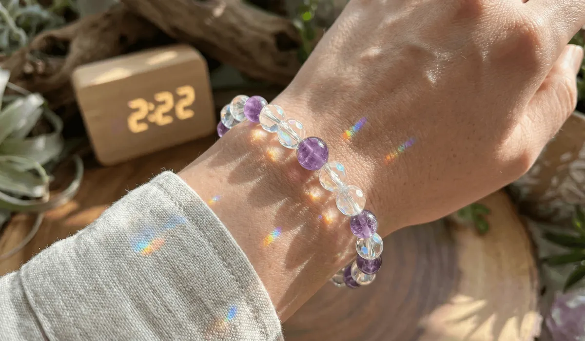 Close-up of spiritual crystal bracelet on a wrist with sun flares, acting as a vibrational amplifier for seeing angel numbers.