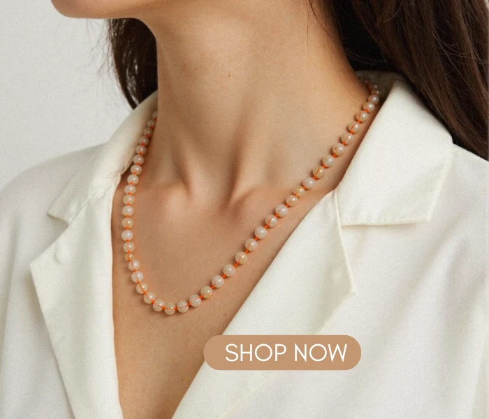 Close-up of a woman in a white blazer wearing a Citrine Radiance Necklace, with a "SHOP NOW" button overlay.