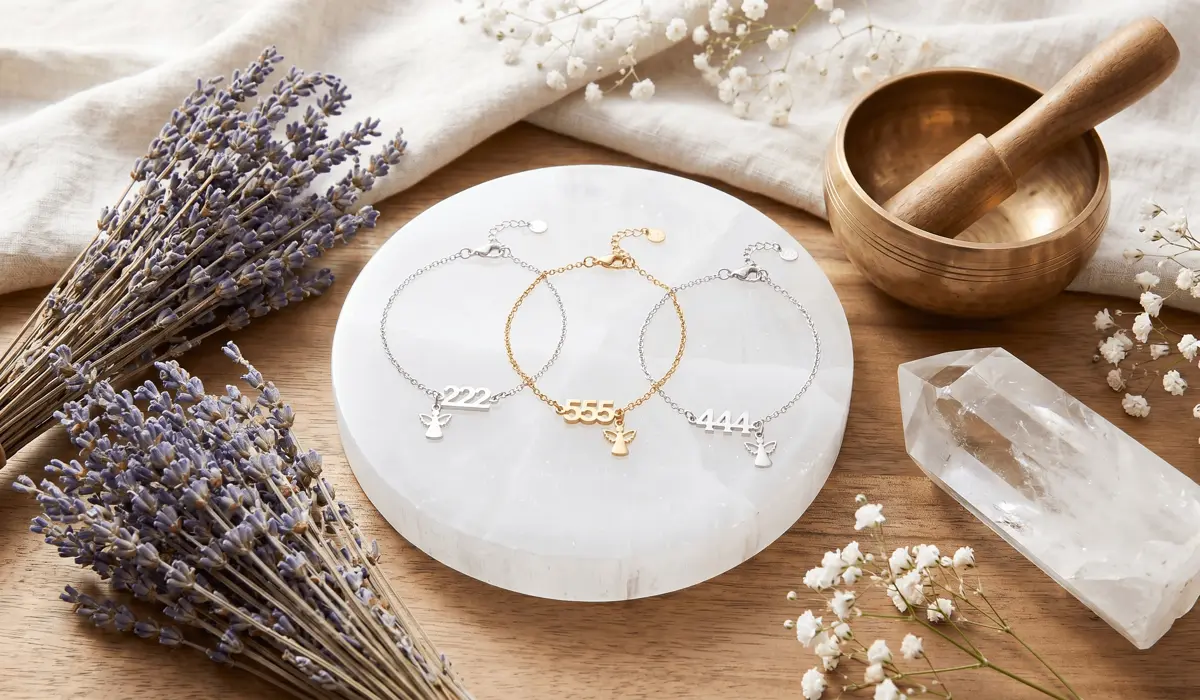 Angel number anklets being charged on a selenite plate with spiritual cleansing tools.