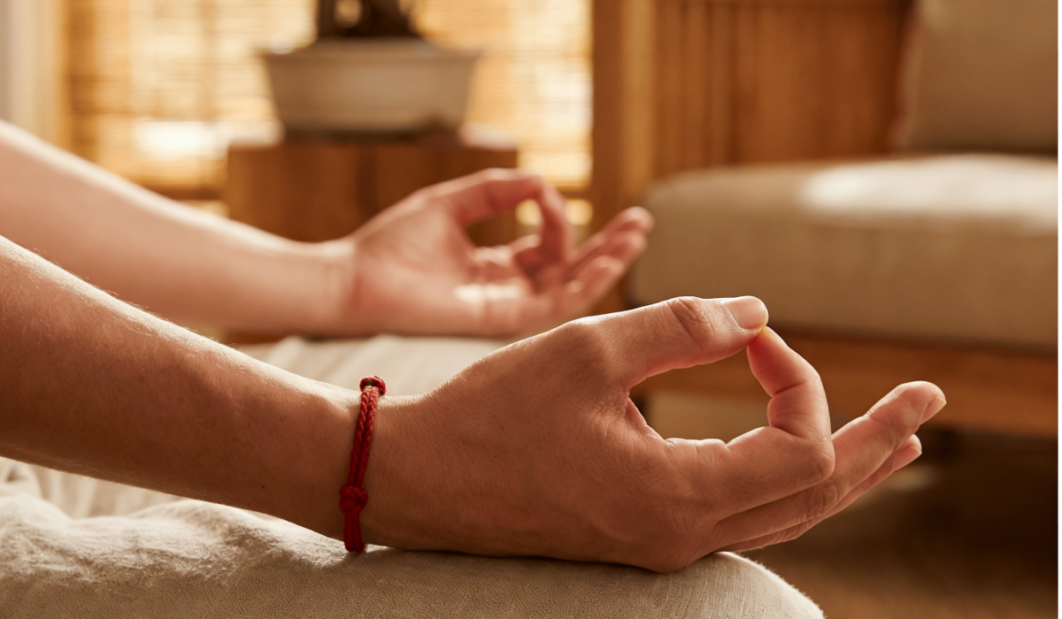 Red string bracelet worn during meditation for balance and Ben Ming Nian energy protection