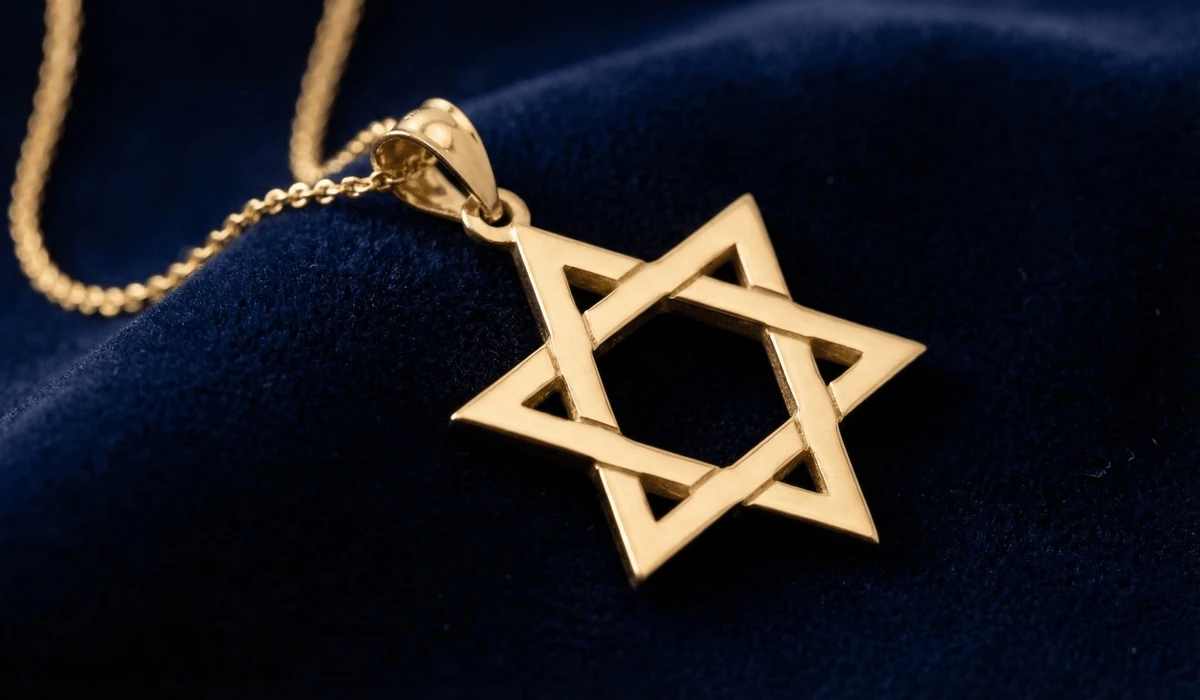 A handcrafted gold Star of David necklace, known as Magen David, showcasing the sacred geometry of the hexagram on a velvet background.
