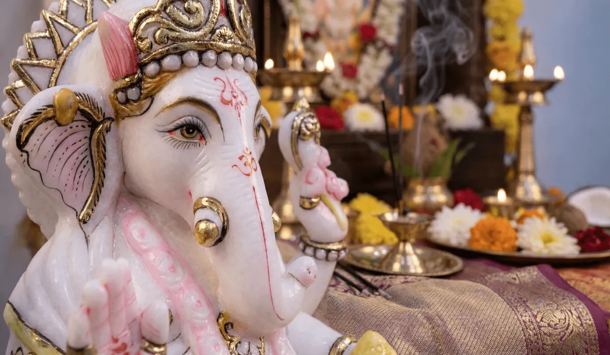 Close-up of a white marble Ganesha idol with a left-turned trunk signifying peace and household prosperity.