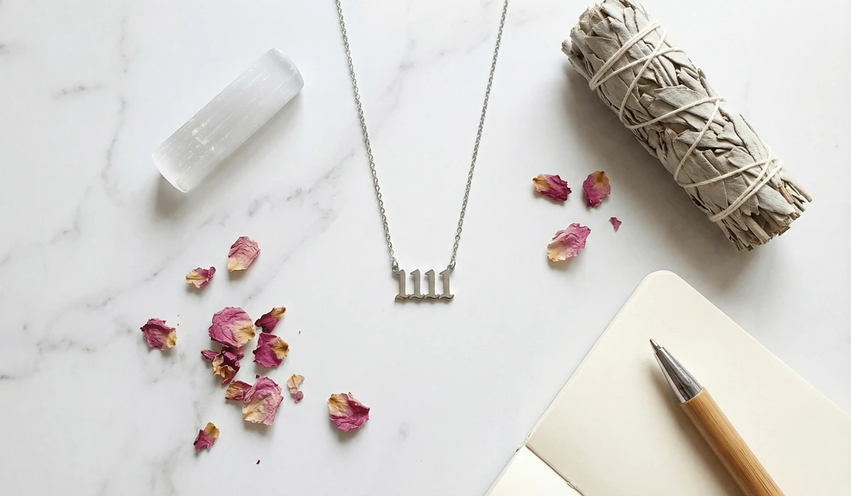 Spiritual flat lay featuring an 1111 necklace with cleansing sage and selenite crystals.