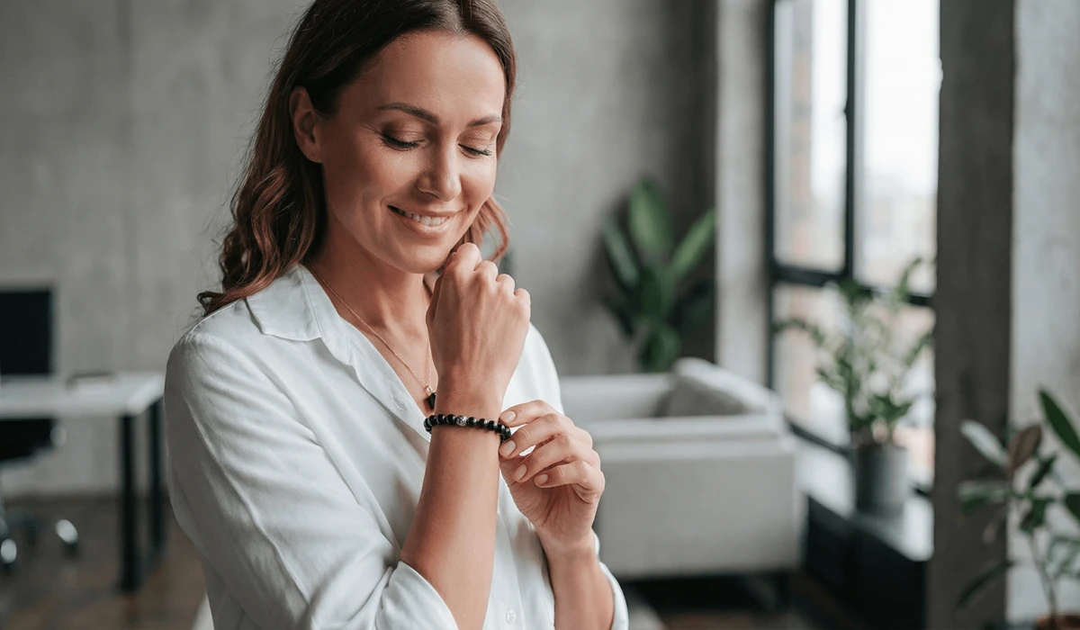 A woman wearing a black tourmaline bracelet on her left hand for emotional stability and energy shielding in a professional environment.