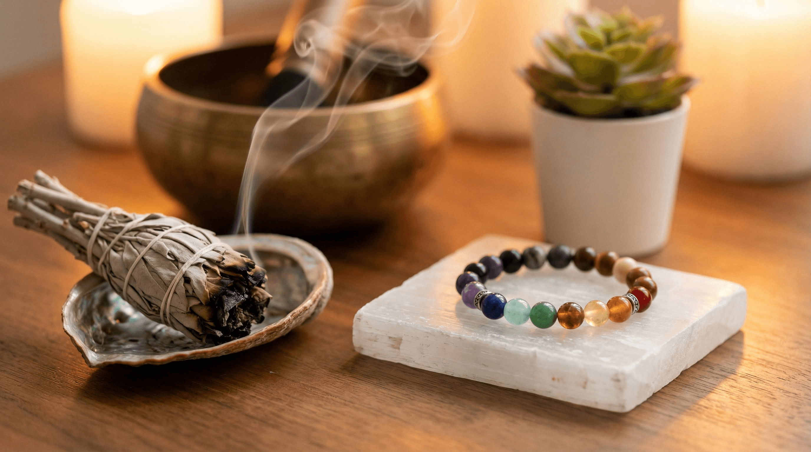 Cleansing a 7 chakra bracelet with sage smoke and a selenite plate to recharge its energy.