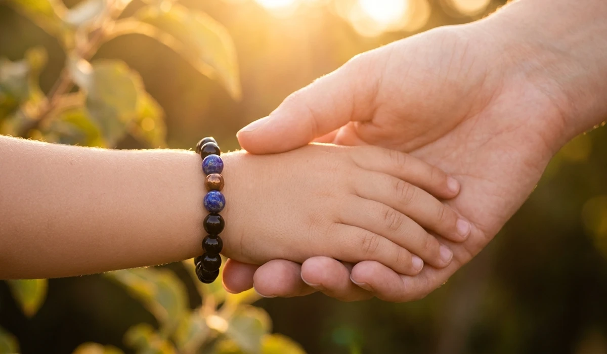 A child wearing a protective Lapis Lazuli and Black Onyx spiritual bracelet on their left wrist for energetic protection.